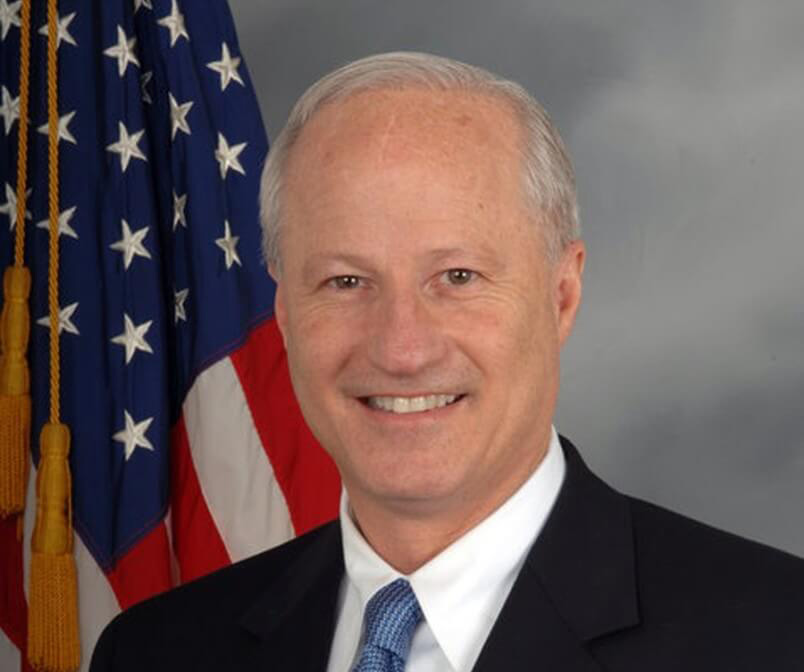 Mike Coffman headshot with American flag